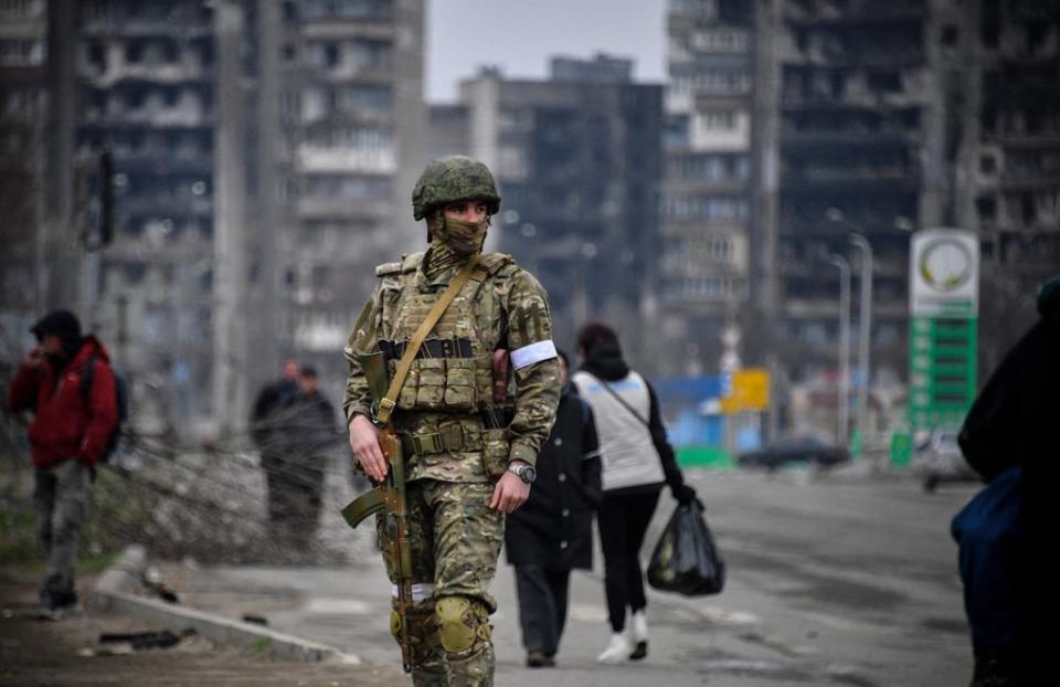 A Russian soldier patrols in a street of Mariupol on 12 April (AFP via Getty Images)