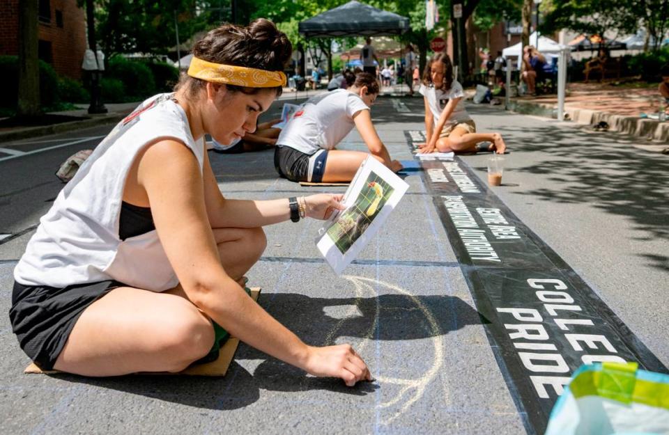 Paige Landay starts the outline of her street painting during the Central Pennsylvania Festival of the Arts on Thursday, July 14, 2022.