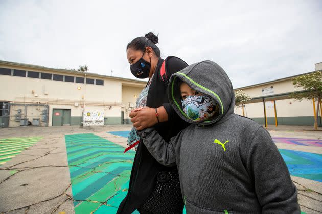 First grade student Daniel Cano, 5, and his mom, Sonia Cano, walk past COVID-19 safety precaution signs at Euclid Avenue Elementary School Monday, July 26, 2021 in Los Angeles. (Photo: Allen J. Schaben via Getty Images)