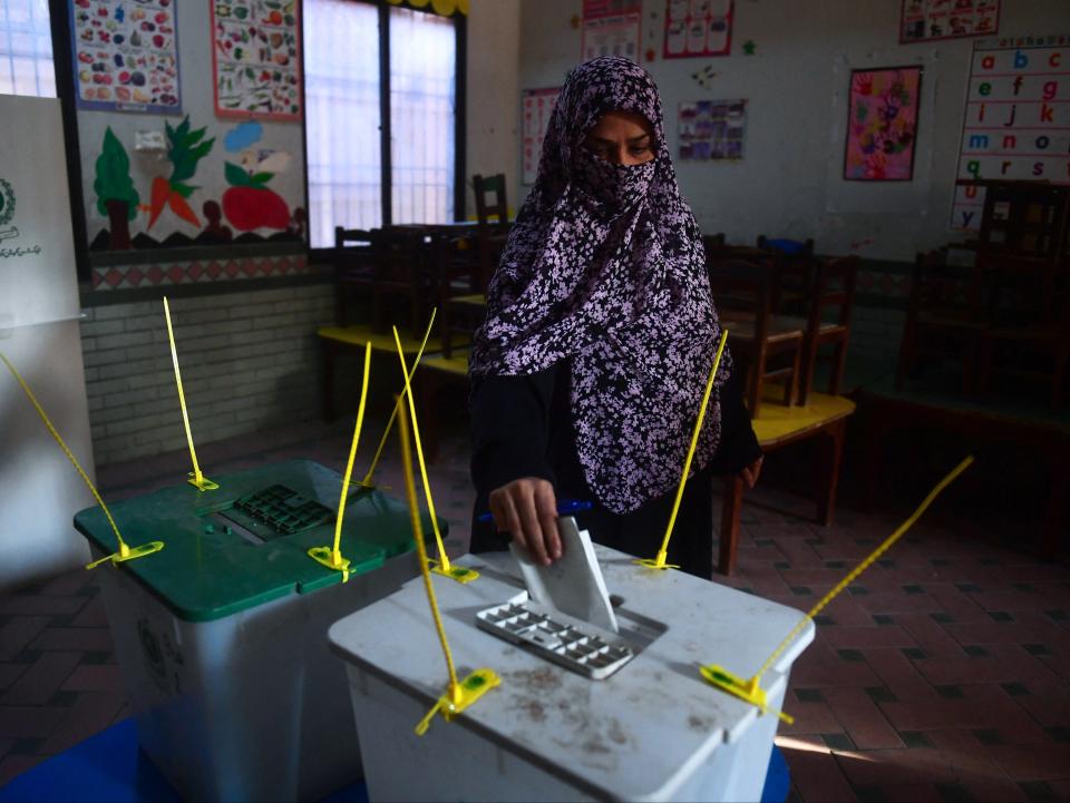 A woman casts her ballot to vote at a polling station during Pakistan’s national elections in Karachi on February 8, 2024. Millions of Pakistanis began voting on February 8 in an election marred by allegations of poll rigging, with the country’s most popular politician in jail and a military-favoured candidate tipped to win (AFP via Getty Images)