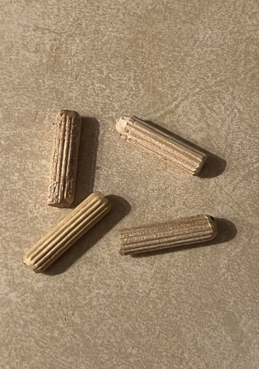 Four textured wooden rods arranged on a flat surface