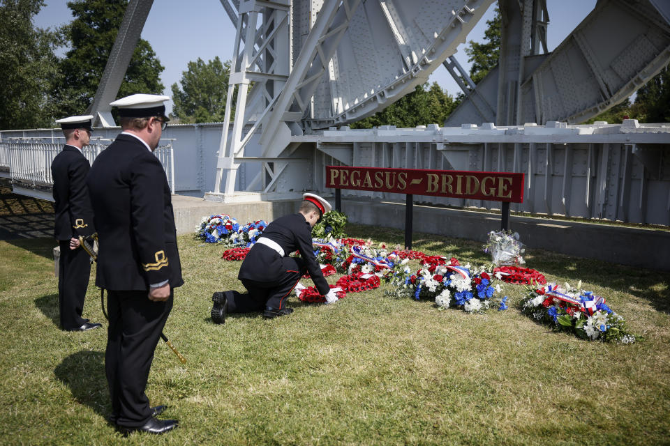 Military officials lay a wreath of flowers at the Pegasus Bridge, one of the first sites liberated by Allied forces from Nazi Germany, in Benouville, Normandy, Monday June 5, 2023. Dozens of World War II veterans have traveled to Normandy this week to mark the 79th anniversary of D-Day, the decisive but deadly assault that led to the liberation of France and Western Europe from Nazi control. (AP Photo/Thomas Padilla)