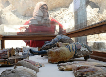 A woman stands near artefacts from the recently discovered tomb of Amenemhat, a goldsmith from the New Kingdom on display at the Draa Abu-el Naga necropolis near the Nile city of Luxor, south of Cairo, Egypt, September 9, 2017. REUTERS/Mohamed Abd El Ghany