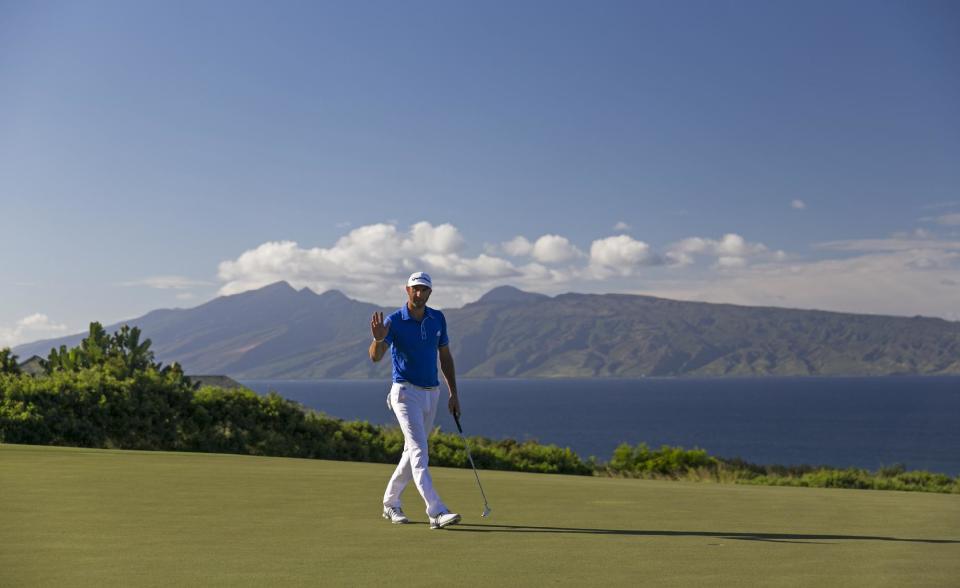 Dustin Johnson waves to the gallery on the 14th green during the third round of the Tournament of Champions golf tournament, Sunday, Jan. 5, 2014, in Kapalua, Hawaii. (AP Photo/Marco Garcia)