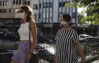 Women wearing a face mask to protect against the spread of coronavirus, walk in Ankara, Turkey, Wednesday, Aug. 19, 2020. Turkey has reported 1,303 new confirmed cases of the coronavirus - the highest daily jump in more than a month.(AP Photo/Burhan Ozbilici)