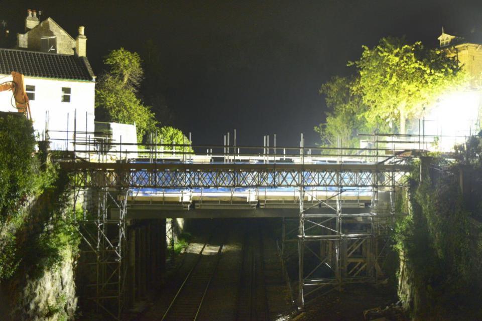 Wiltshire Times: The bridge over the railway illuminated as work to remove it was scheduled to take place but is