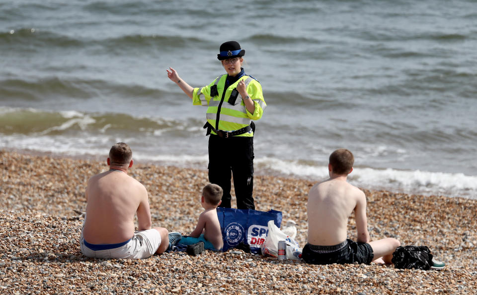 A police officer advises people to leave the beach during the warm weather in Brighton as the UK continues in lockdown to help curb the spread of the coronavirus. (Photo by Gareth Fuller/PA Images via Getty Images)