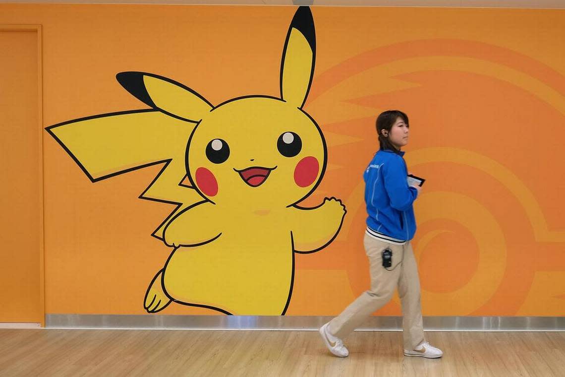An employee walks past a wall featuring the Pikachu character at the Pokemon Center Mega Tokyo store in Tokyo.