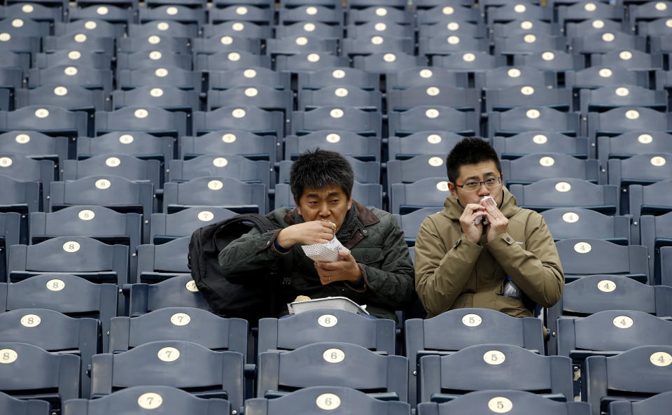 FILE - In this April 15, 2018, file photo, fans finish their food before exiting Kauffman Stadium after a baseball game between the Kansas City Royals and the Los Angeles Angels was postponed due to inclement weather in Kansas City, Mo. As lock-downs are lifted, restrictions on social gatherings eased and life begins to resemble some sense, sports are finally starting to emerge from the coronavirus pandemic. When stadiums do reopen for fans, how are teams going to drive them through the gate? (AP Photo/Charlie Riedel, File)