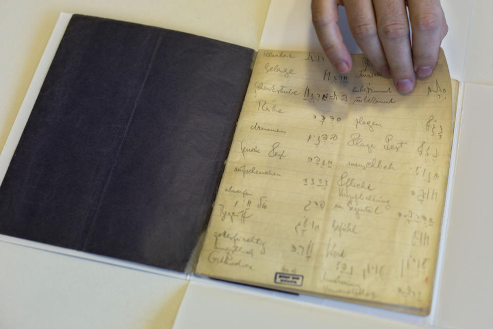 FILE - In this file photo taken on Oct. 5, 2014, a library official shows celebrated author Franz Kafka's Hebrew vocabulary notebook at Israel's National Library in Jerusalem. A long-hidden trove of unpublished works by Franz Kafka could soon be revealed following a decade-long battle over his literary estate that has drawn comparisons to some of his surreal tales. (AP Photo/Sebastian Scheiner, File)