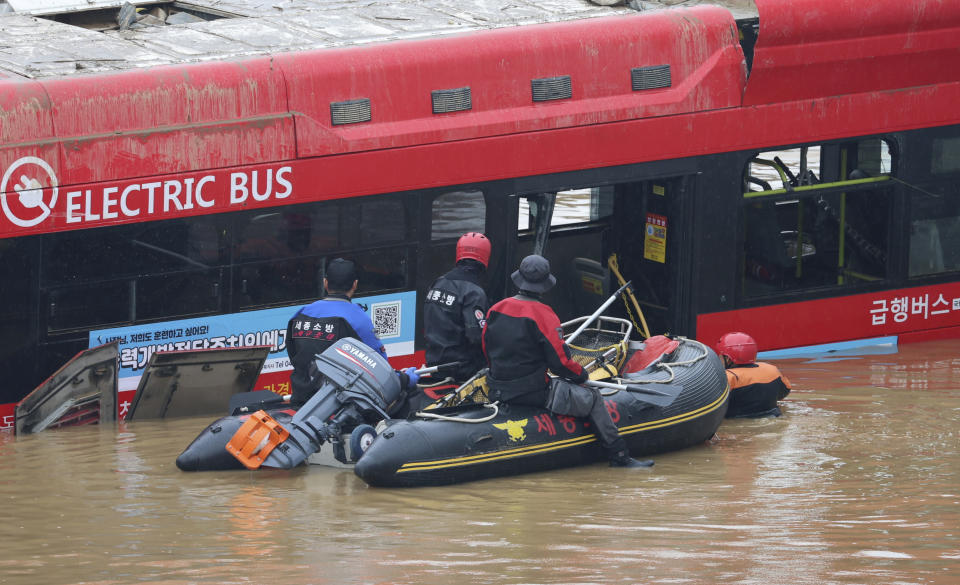 Rescuers conduct a search operation along a road submerged by floodwaters leading to an underground tunnel in Cheongju, South Korea, Sunday, July 16, 2023. Days of heavy rain triggered flash floods and landslides and destroyed homes, leaving scores of people dead and forcing thousands to evacuate, officials said Sunday. (Kim Ju-hyung/Yonhap via AP)