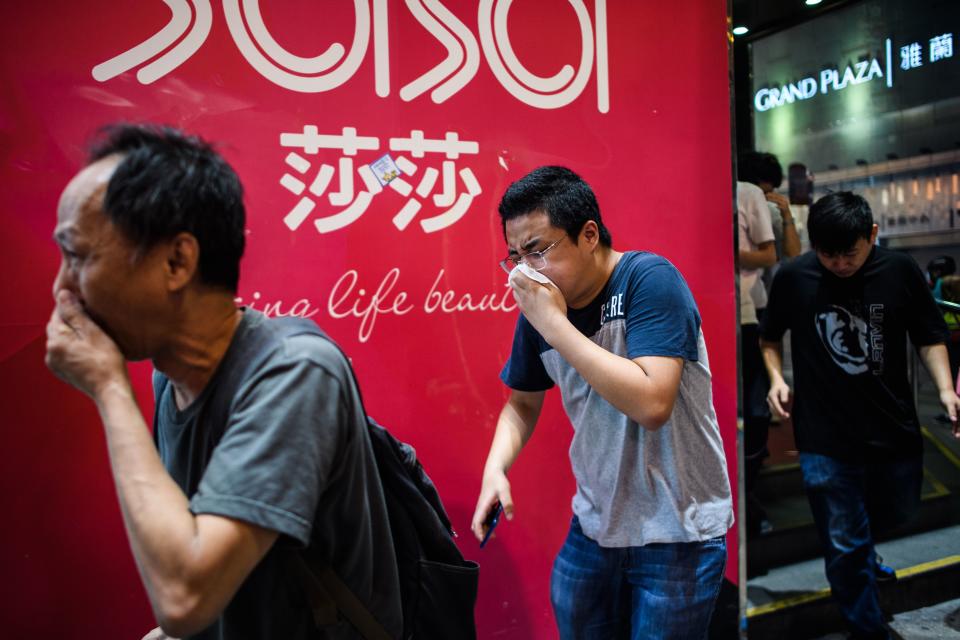 Bystanders react after police fired tear gas to disperse residents and protesters in the Mong Kok district of Kowloon in Hong Kong on October 27, 2019. | ANTHONY WALLACE—AFP via Getty Images