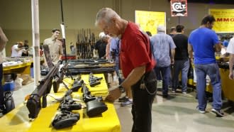 A customer looks a rifles on display at a gun show in Florida.