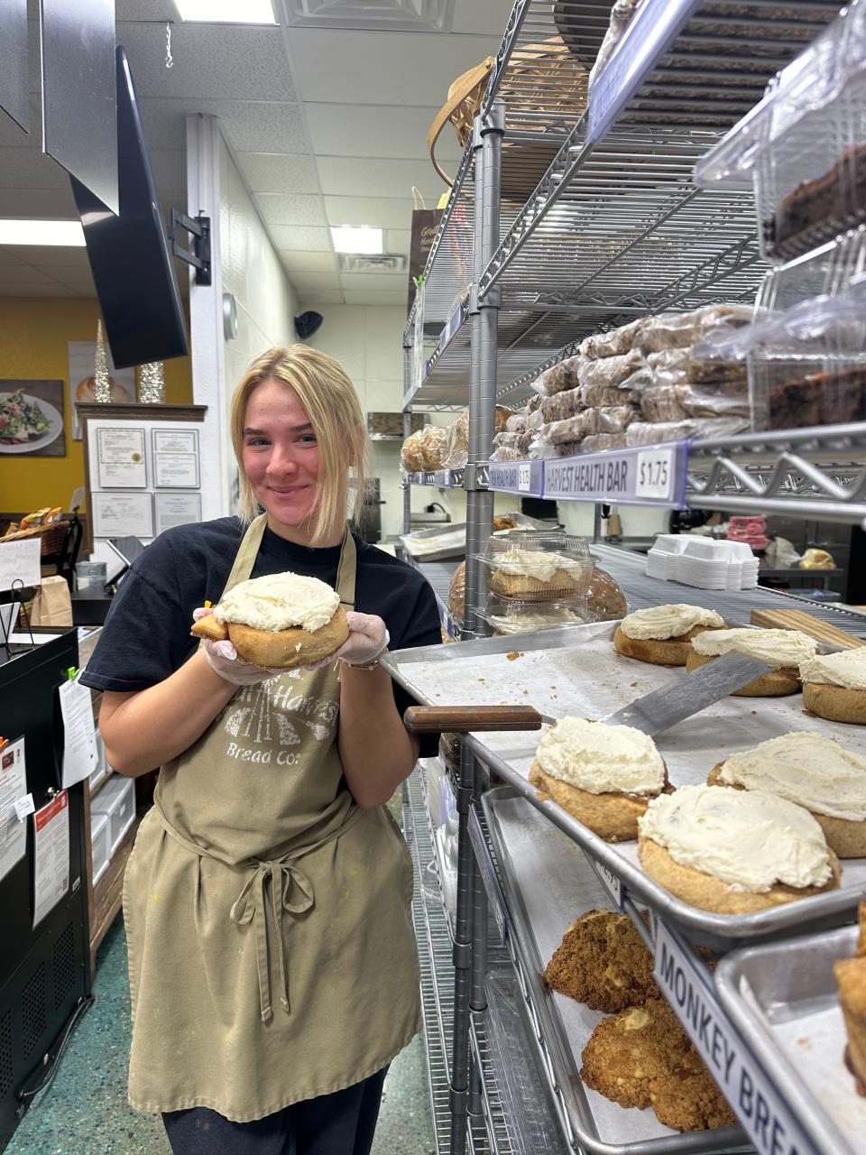McKenya Williams poses by a batch of whole grain cinnamon rolls at Great Harvest Bakery & Café in Ames.