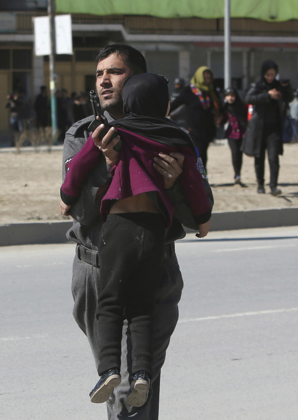 Afghan security police carries a girl after a suicide bombing in Kabul, Afghanistan, Wednesday, March 1, 2017. A pair of suicide bombings, both claimed by the Taliban, struck the Afghan capital, an Afghan official said. (AP Photo/Rahmat Gul)