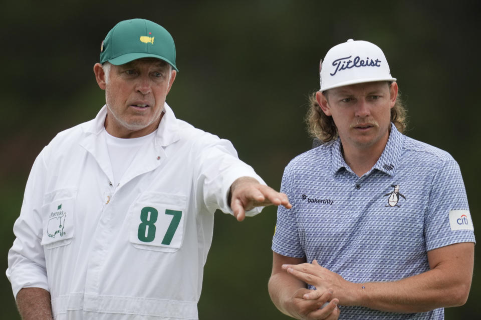 Cameron Smith, of Australia, speaks with a caddie during a practice for the Masters golf tournament at Augusta National Golf Club, Tuesday, April 4, 2023, in Augusta, Ga. (AP Photo/Mark Baker)