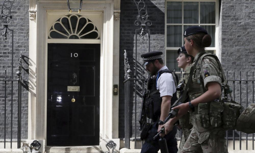 Members of the army join a police officer outside 10 Downing Street.