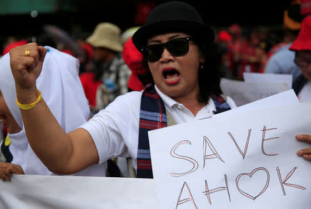 A supporter of former Jakarta Governor Basuki Tjahaja Purnama or Ahok holds a placard during a protest in front of North Jakarta District Court in Jakarta, Indonesia February 26, 2018. REUTERS/Beawiharta