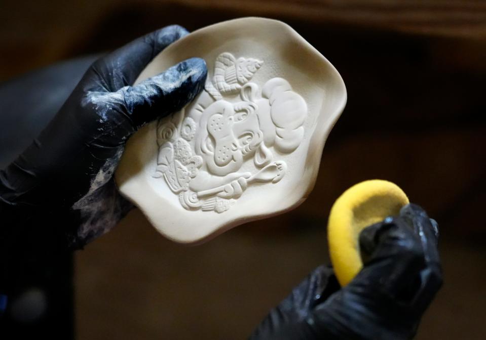 Katherine Schwarz cleans up a Fiona spoon prior to glazing at Rookwood Pottery.