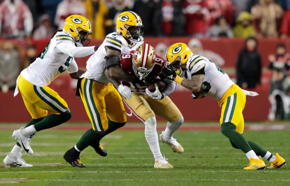 Green Bay Packers linebacker De'Vondre Campbell, linebacker Quay Walker and cornerback Jaire Alexander tackle San Francisco 49ers wide receiver Deebo Samuel on Jan. 20 during their NFC divisional playoff football game in Santa Clara, California.