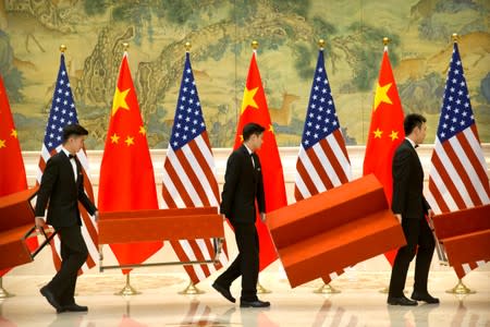 Aides set up platforms before a group photo with members of U.S. and Chinese trade negotiation delegations at the Diaoyutai State Guesthouse in Beijing