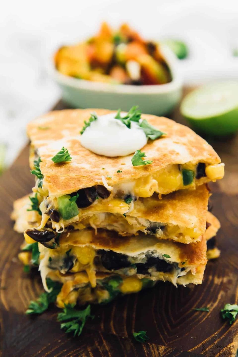 A stack of black bean quesadilla slices sprinkled with chopped cilantro.