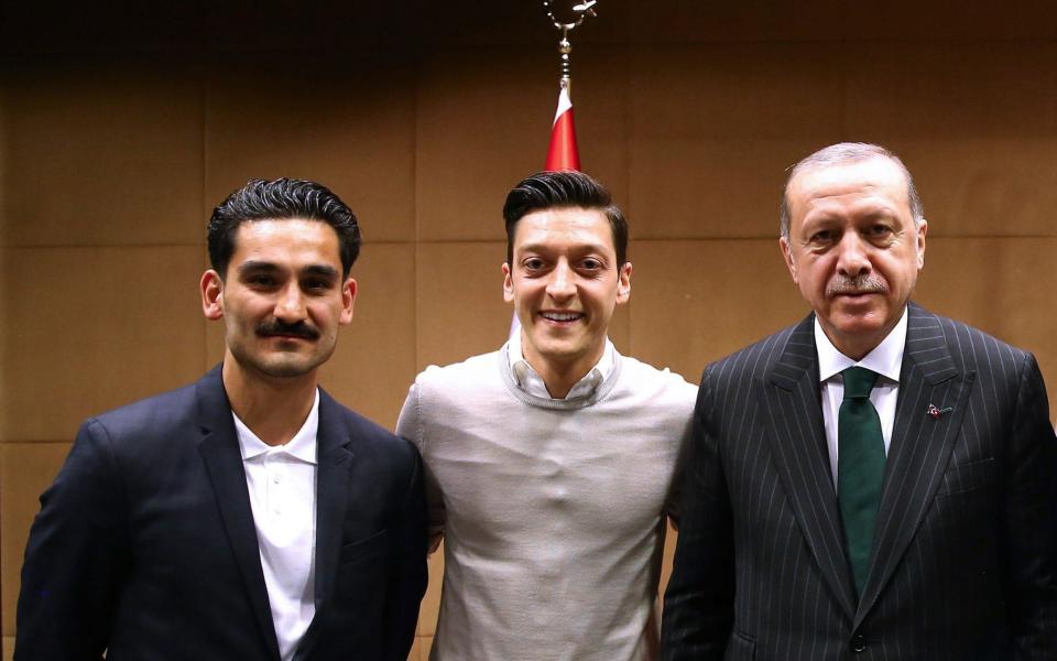 Turkish President Recep Tayyip Erdogan poses for a photo with Ilkay Gundogan and Mesut Ozil - AFP