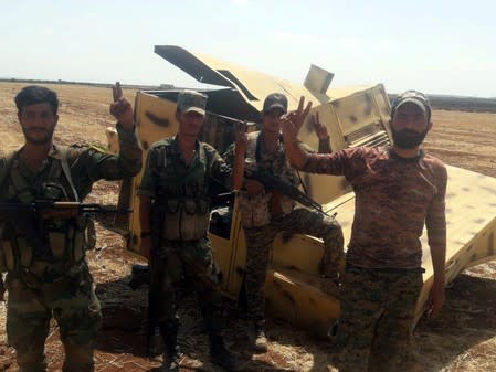 Syrian army soldiers gesture as they pose for a picture in Idlib countryside