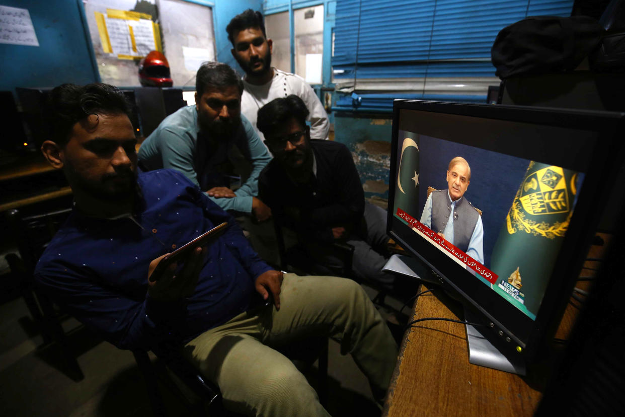 People listen to a televised speech by Pakistani Prime Minister Shehbaz Sharif in Karachi, Pakistan, on May 27, 2022.
