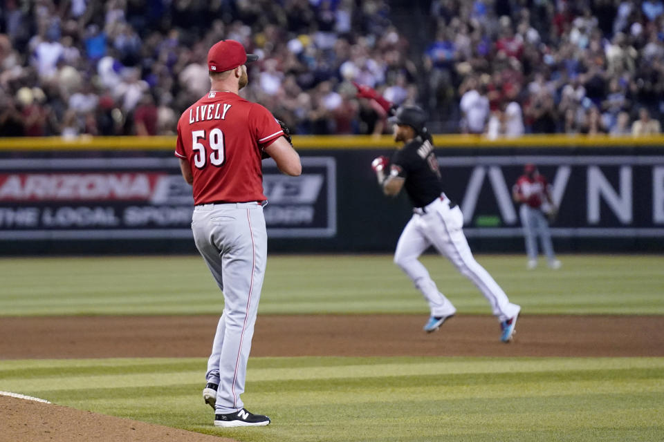 Cincinnati Reds relief pitcher Ben Lively (59) pauses behind the mound after giving up a three-run home run to Arizona Diamondbacks' Ketel Marte, right, during the fifth inning of a baseball game Saturday, Aug. 26, 2023, in Phoenix. (AP Photo/Ross D. Franklin)