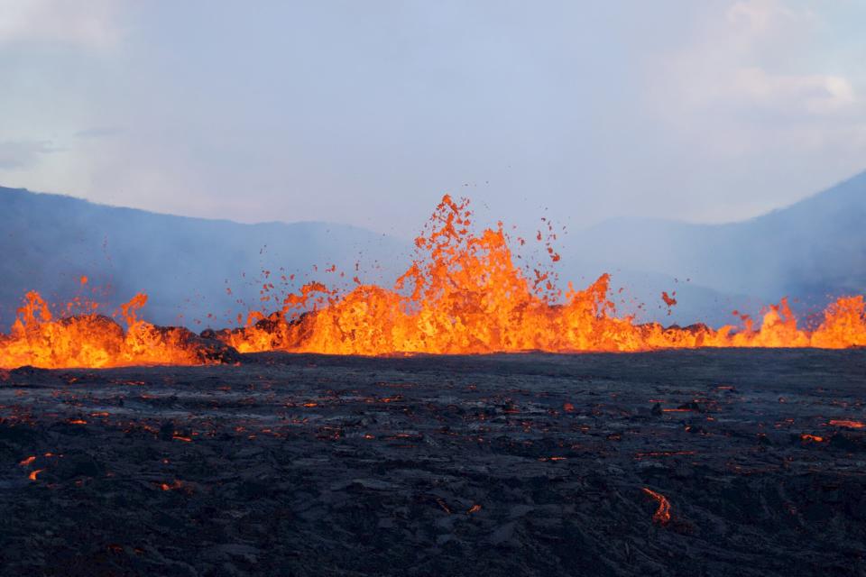 Lava erupts and flows at the scene of the newly erupted volcano at Grindavik, Iceland on August 3, 2022. - A volcano erupted on August 3, 2022 in Iceland in a fissure near Reykjavik, the Icelandic Meteorological Office (IMO) said as lava could be seen spewing out of the ground in live images on local media. The eruption was some 40 kilometres (25 miles) from Reykjavik, near the site of the Mount Fagradalsfjall volcano that erupted for six months in March-September 2021, mesmerising tourists and spectators who flocked to the scene.