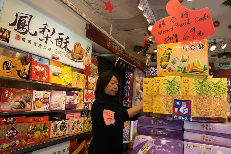 A vendor arrange boxes of pineapple tarts at a shop selling Taiwanese snacks in Taipei, Taiwan, Thursday, Jan. 11, 2024. Beijing's threats to use force to claim self-governed Taiwan aren't just about missiles and warships. Hard economic realities will be at play as voters head to the polls on Saturday, though the relationship is complicated. (AP Photo/Ng Han Guan)