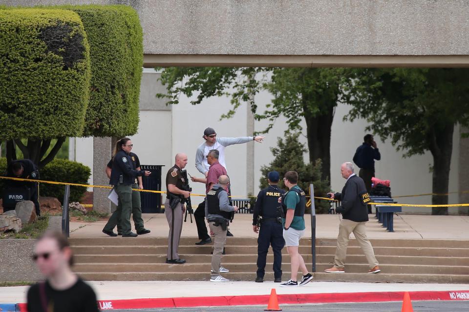 Law enforcement stand outside a building near the scene of a shooting that left one dead on the campus of Rose State College in Midwest City, Okla., Monday, April 24, 2023.
