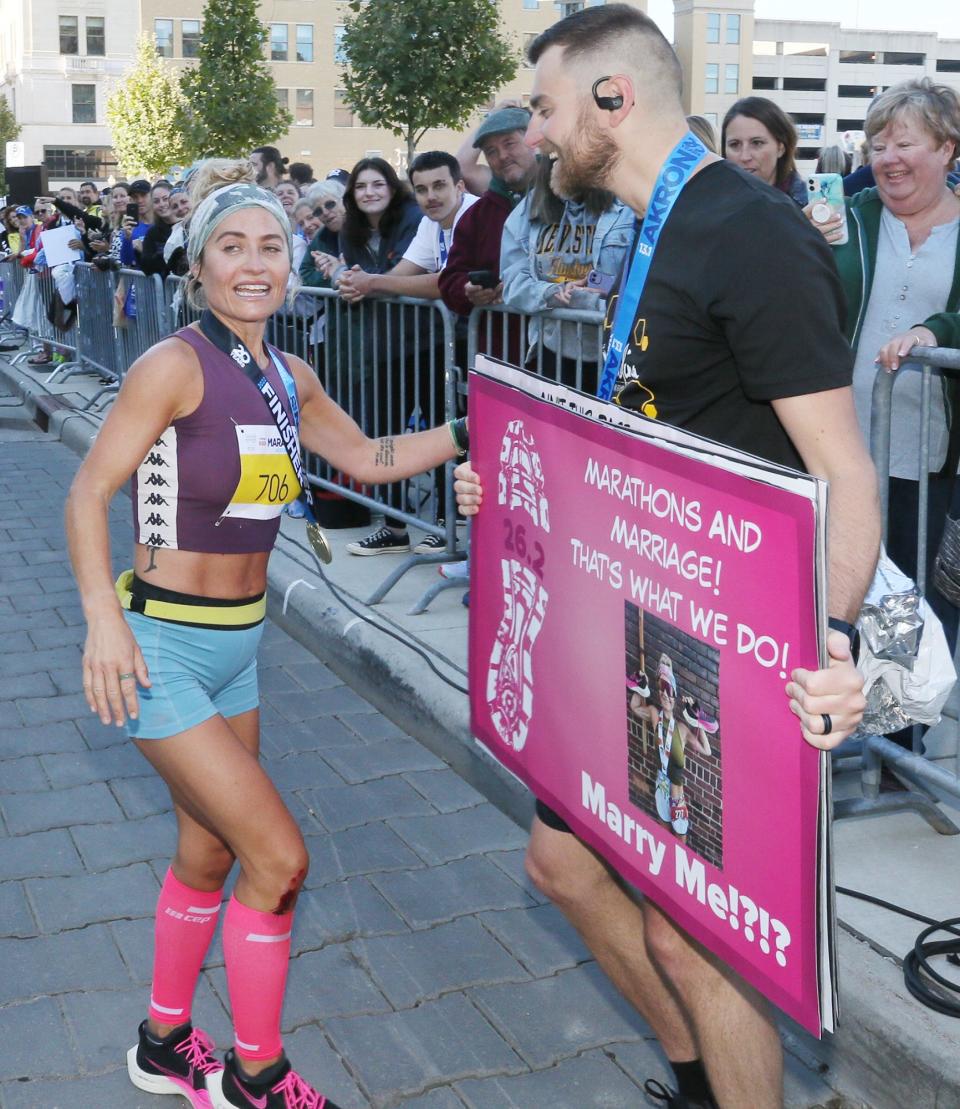 Vincent Reddish proposes to Alysia Rogers, who was the women’s first-place finisher in the Akron Marathon.