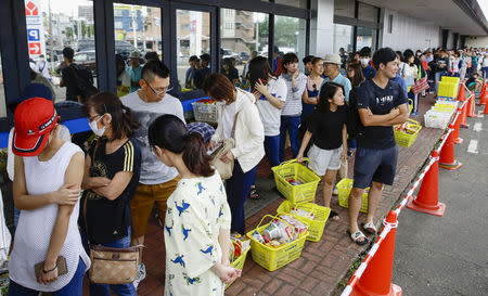 People line up to buy foods outside a store after an earthquake hit the area in Sapporo, Hokkaido, northern Japan, in this photo taken by Kyodo September 6, 2018. Kyodo/via REUTERS