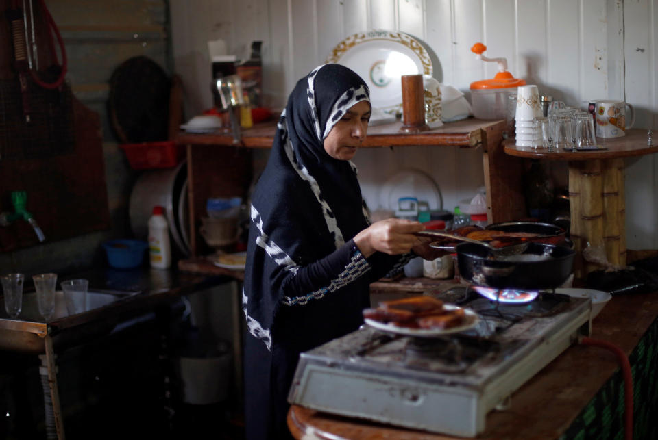 Aisha prepares Iftar food for her family and her husband's troupe members at the Al-Zaatari camp June 1.