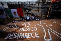 <p>Demonstrators sit next to a graffiti that reads “43 (for the missing students of Ayotzinapa College) - Mexico dissapears” outside the Casa Rosada Presidential Palace during a protest against the visit to Argentina by Mexico’s President Enrique Pena Nieto, in Buenos Aires, Argentina, July 29, 2016. (Photo: Marcos Brindicci/Reuters)</p>