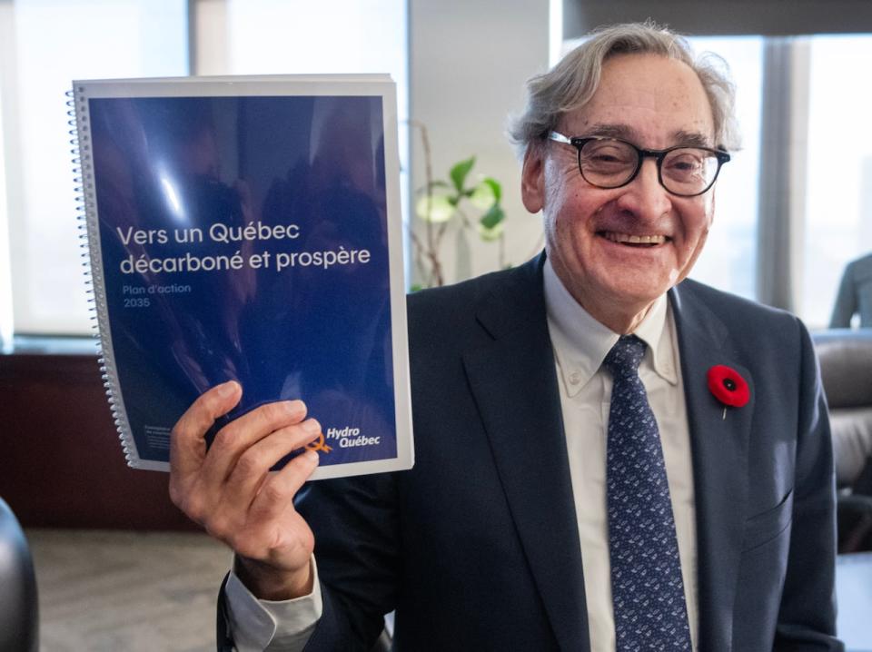 Hydro Quebec chief executive Michael Sabra holds up a copy of the company’s plans for the future, after they were made public on Nov. 2, 2023.