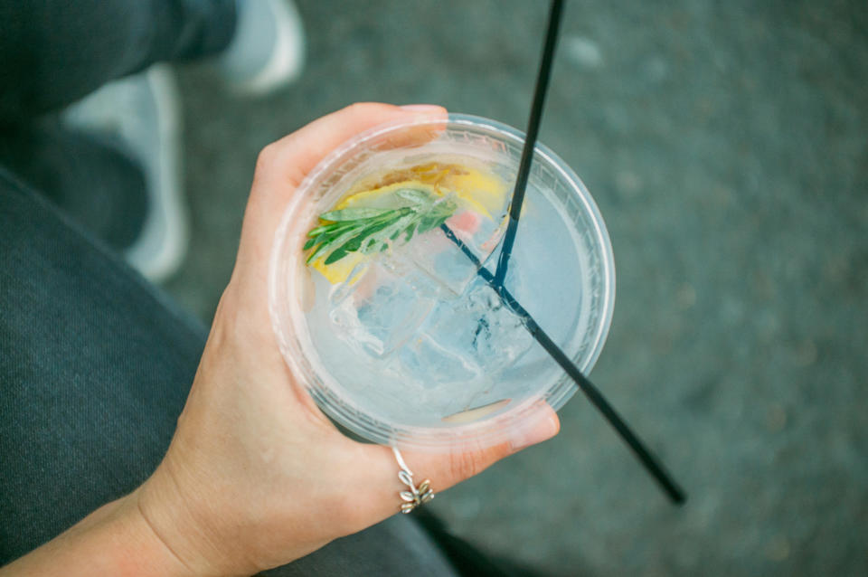 A hand holding a cocktail with tonic water.