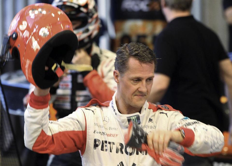 FILE - This is a Sunday, Dec. 16, 2012. file photo of Michael Schumacher of Germany as he holds a helmet after a test drive prior to the Race Of Champions at Rajamangala national stadium in Bangkok, Thailand. Doctors in Grenoble France treating former seven-time World Formula One champion Michael Schumacher refused Monday Dec. 30, 2013 to predict the outcome for the former Formula One driver, saying they were taking his very critical head injury "hour by hour” following his ski accident in Meribel, France on Sunday. (AP Photo/Apichart Weerawong, File)