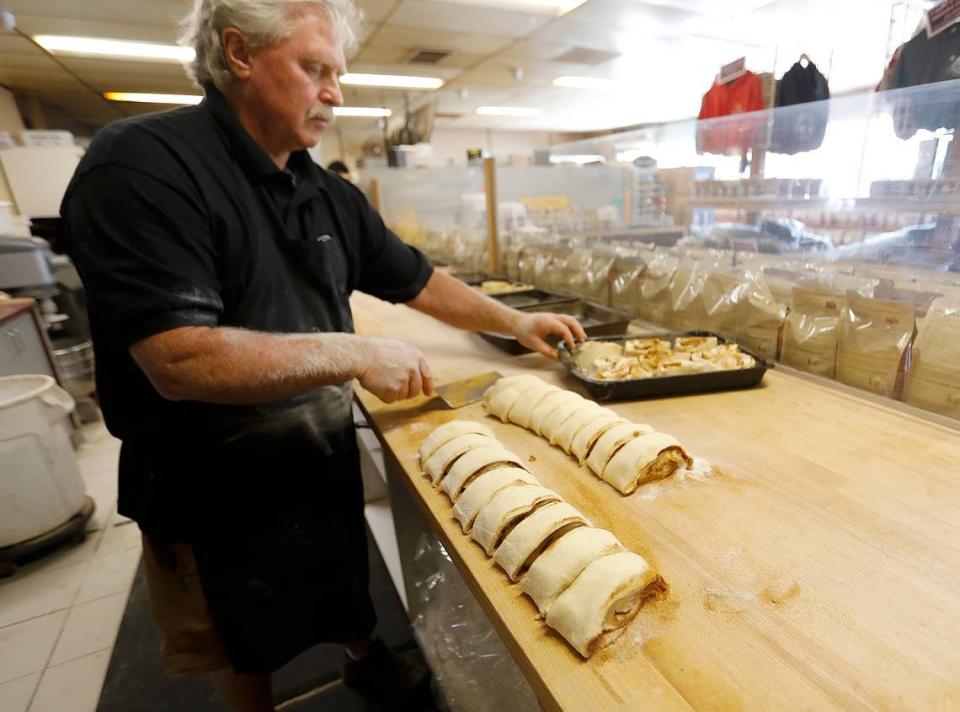 Old West Cinnamon Rolls co-owner Joe Parkhurst starts with a huge layer of dough, before adding margarine, sugar and cinnamon. He then rolls up the dough and slices it to make the rolls. They are left to rise and then baked. The shop has been a Pismo Beach institution since 1981.