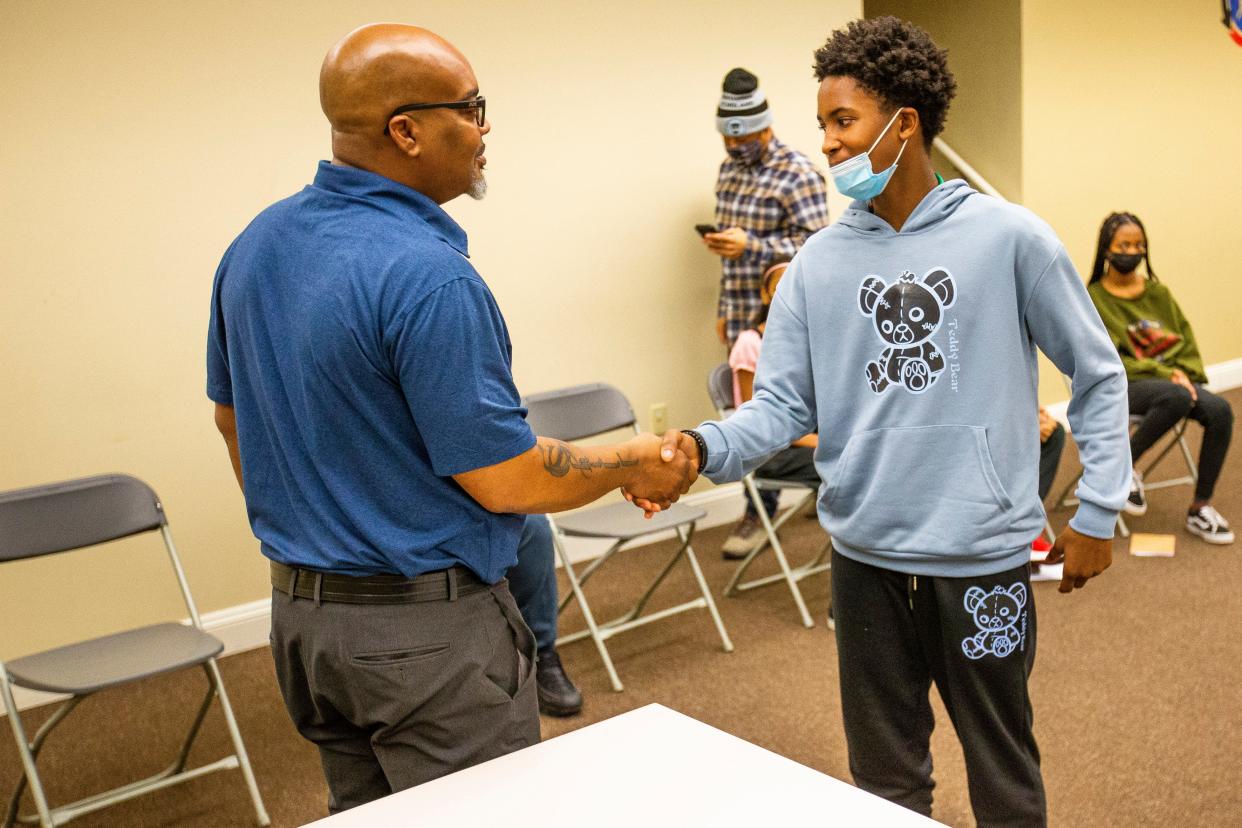 William Douglas shakes hands with Ayden Monroe during an etiquette class put on by the Gentlemen and Scholars group Thursday, Jan. 13, 2022, at the IMPower Center in South Bend.