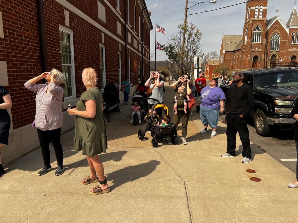 People are gathered in downtown Lancaster on April 8, 2024, to watch the solar eclipse.