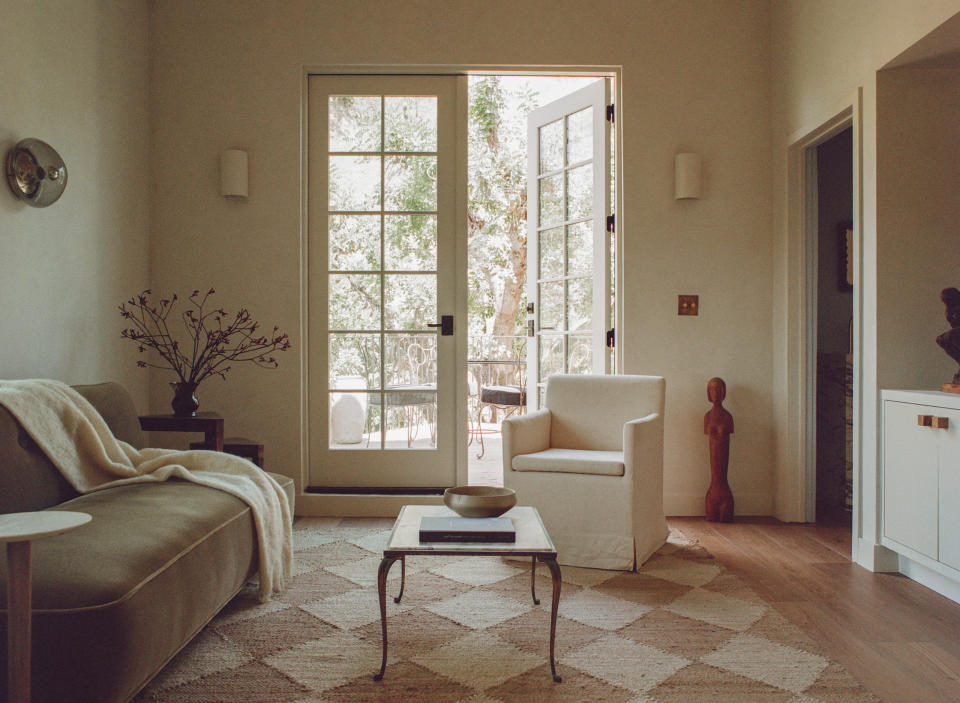 A neutral living room with checked rug