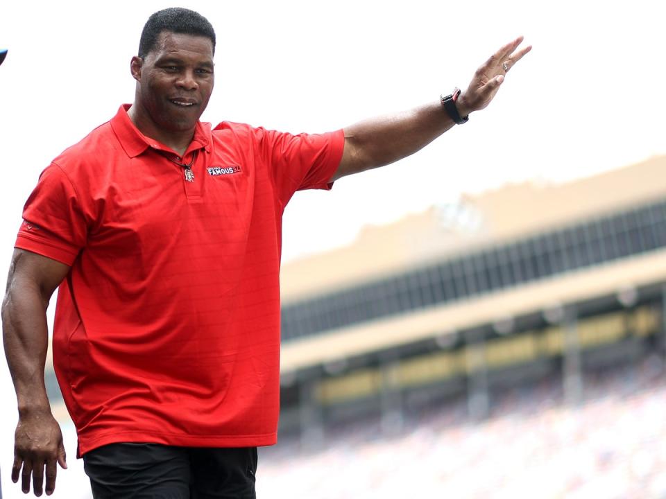 Republican candidate for US Senate Herschel Walker waves to fans as he walks onstage during pre-race ceremonies prior to the NASCAR Cup Series Quaker State 400 at Atlanta Motor Speedway on July 10, 2022 in Hampton, Georgia (Getty Images)