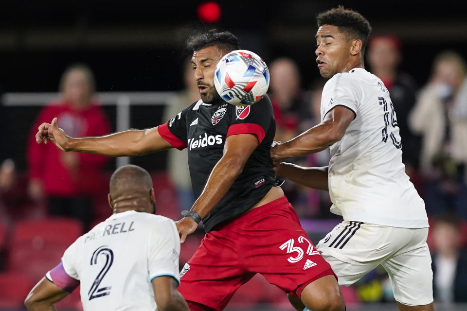 D.C. United forward Ramon Abila heads the ball with New England Revolution defender Andrew Farrell (2) and midfielder Brandon Bye (15) nearby during the second half of an MLS soccer match, Wednesday, Oct. 20, 2021, in Washington. The Revolution won 3-2. (AP Photo/Alex Brandon)