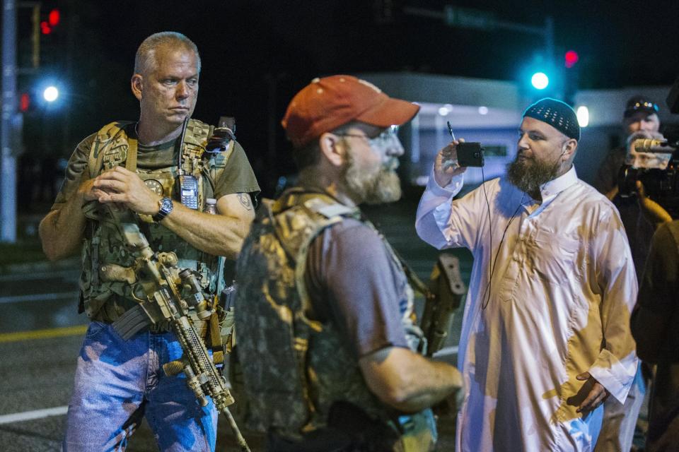 Members of the Oath Keepers walk with their personal weapons on the street during protests in Ferguson, Missouri August 11, 2015. Police in riot gear clashed with protesters who had gathered in the streets of Ferguson early on Tuesday to mark the anniversary of the police shooting of an unarmed black teen whose death sparked a national outcry over race relations. REUTERS/Lucas Jackson