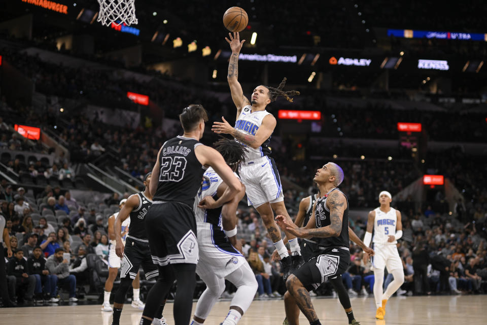 Orlando Magic's Cole Anthony, center, shoots during the first half of an NBA basketball game against the San Antonio Spurs, Tuesday, March 14, 2023, in San Antonio. (AP Photo/Darren Abate)