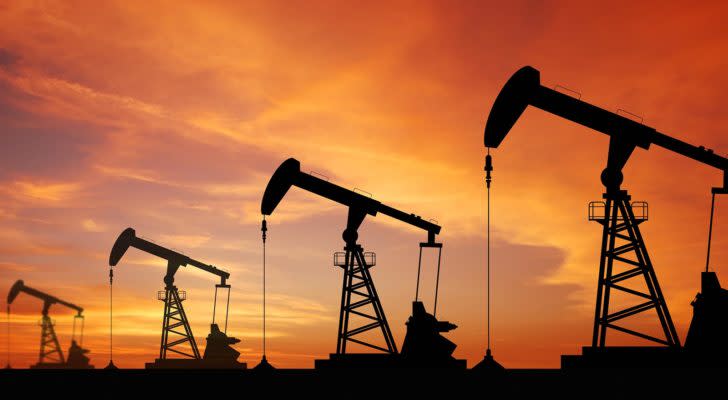 Image of an oil wells with an orange-red sky at dusk