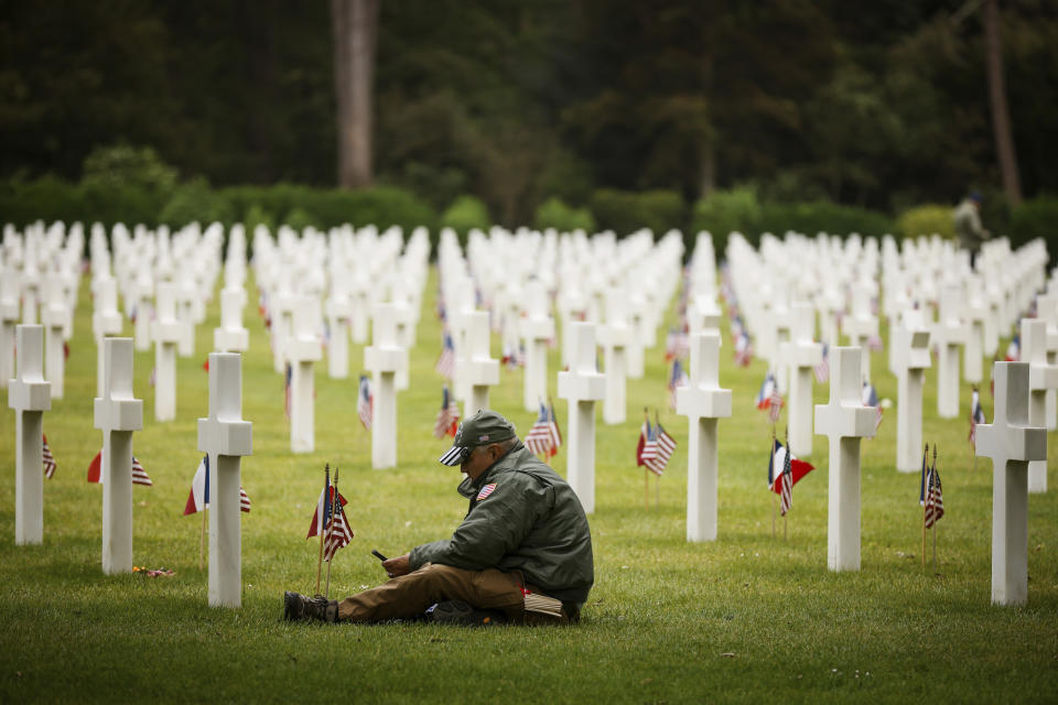 FILE - A man sits by gravestones in the the American Cemetery during a ceremony to mark the 79th anniversary of the assault that led to the liberation of France and Western Europe from Nazi control, in Colleville-sur-Mer, Normandy, France, June 6, 2023. France is getting ready to show its gratitude towards World War II veterans who will come, many for the last time, on Normandy beaches for D-Day ceremonies that will come as part of a series of major commemorations this year and next marking eight decades since the defeat of the Nazis. (AP Photo/Thomas Padilla, File)